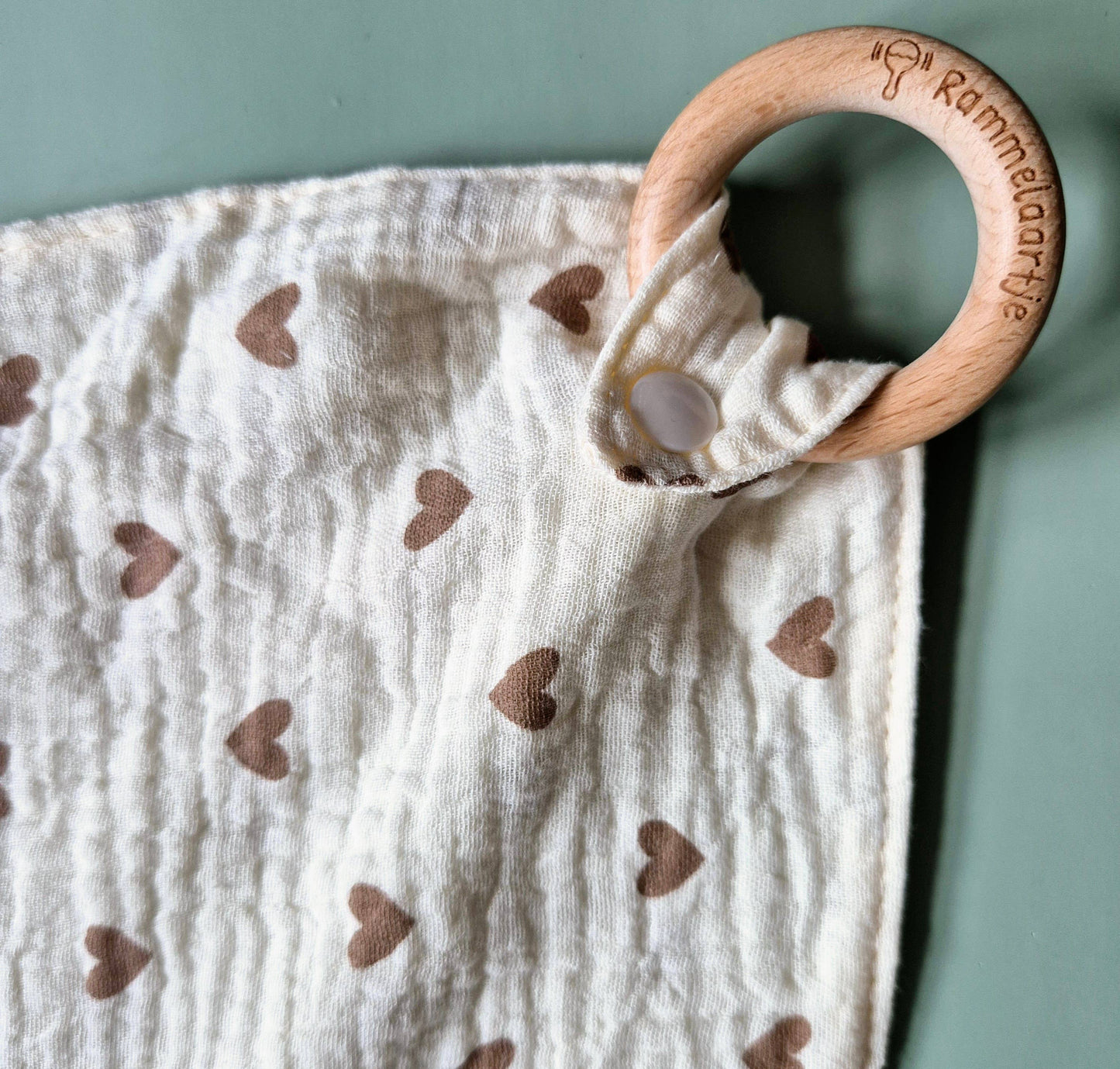 Kuscheltuch mit Beißring aus Buche mit Herzen-Motiv. Holzring Nahaufnahme.