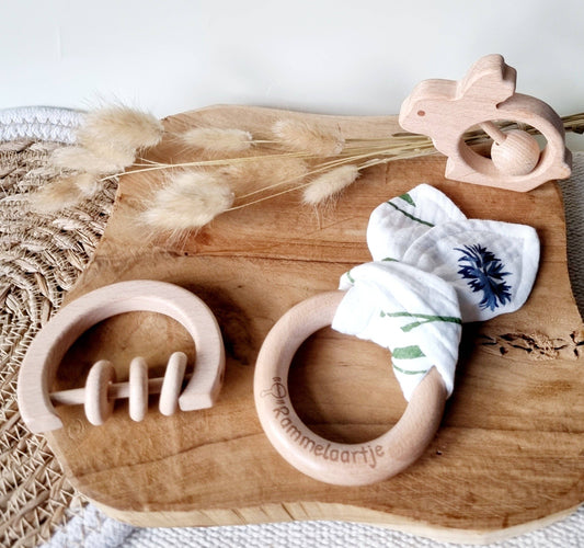 Holzrassel für Babys auf einem Brett
