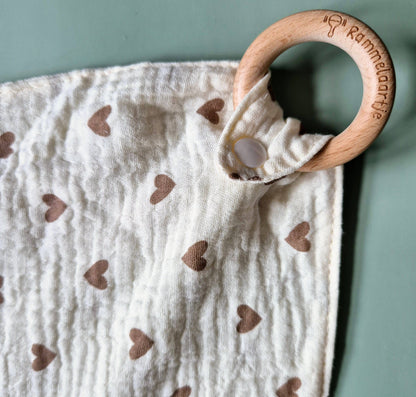 Kuscheltuch mit Beißring aus Buche mit Herzen-Motiv. Holzring Nahaufnahme.