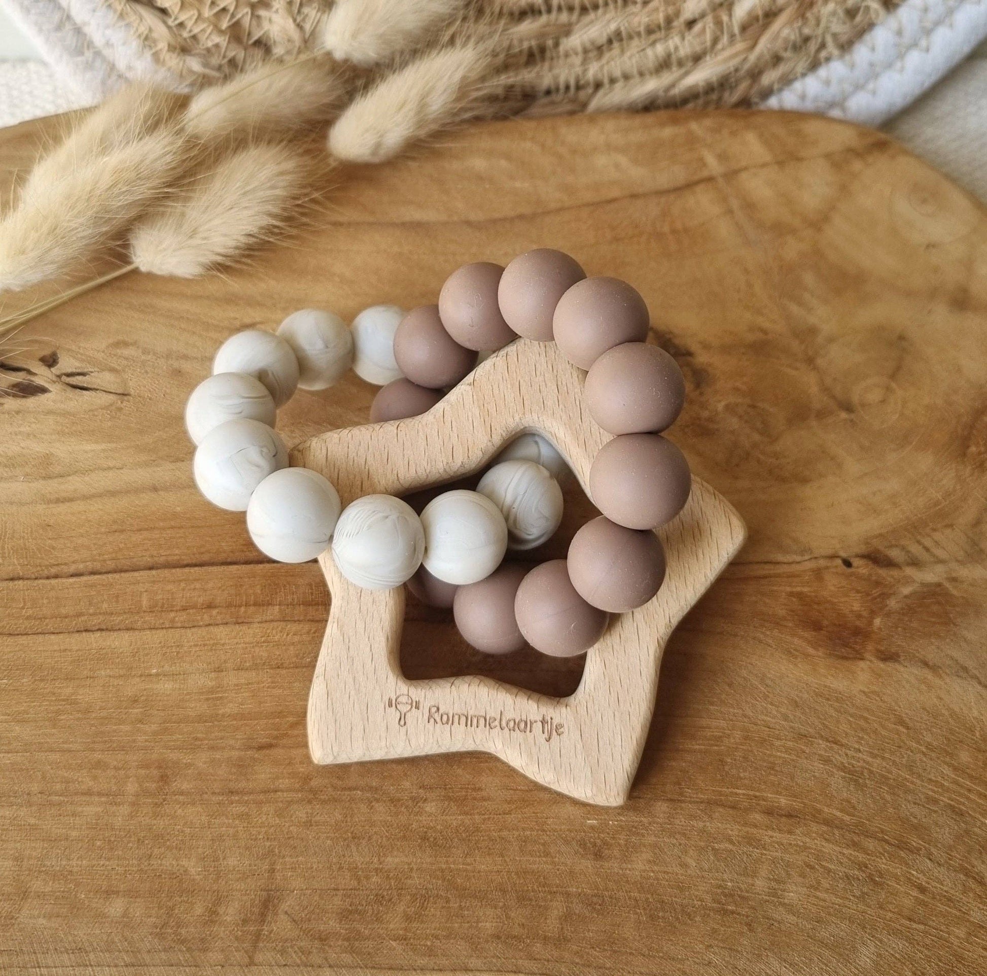 Nahaufnahme des Beißrings mit braunen und marmorierten Silikonperlen am Holzstern